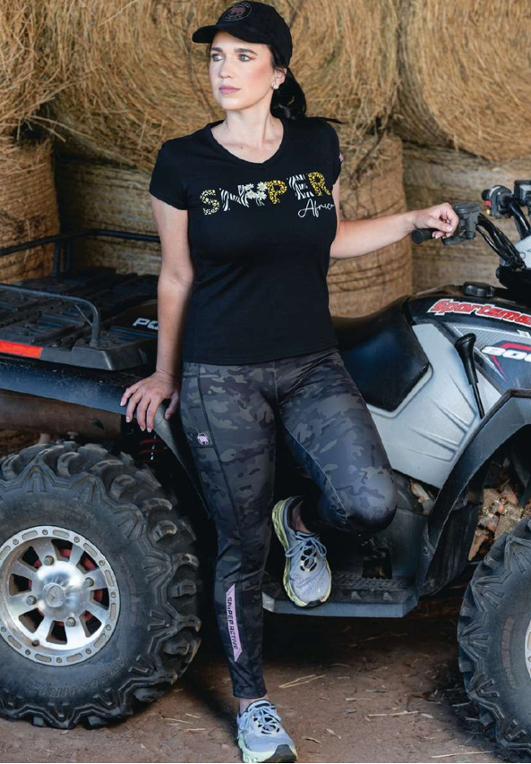 Woman standing next to an ATV with hay bales in the background